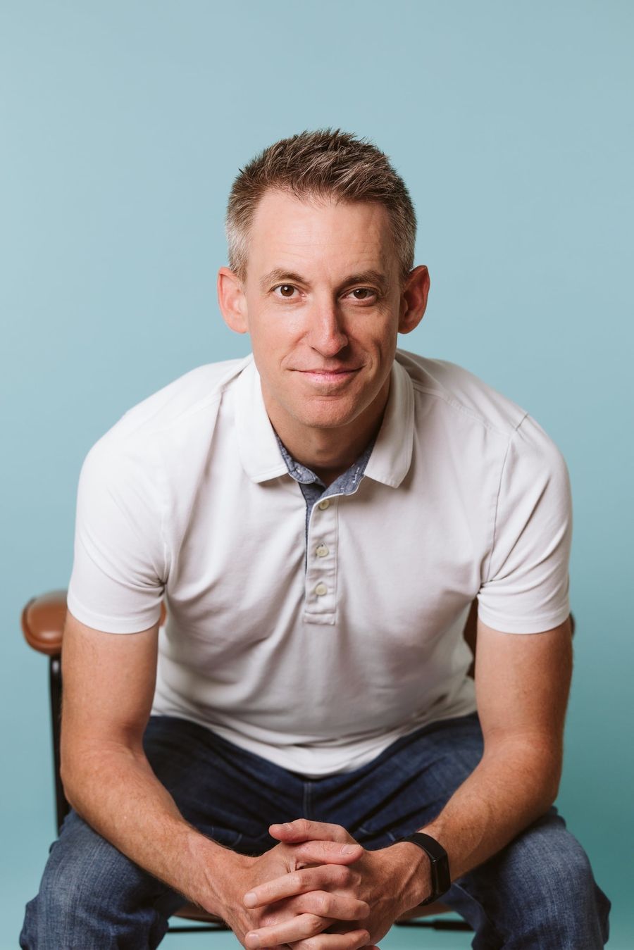 Jason Kander, seated, in a white polo shirt